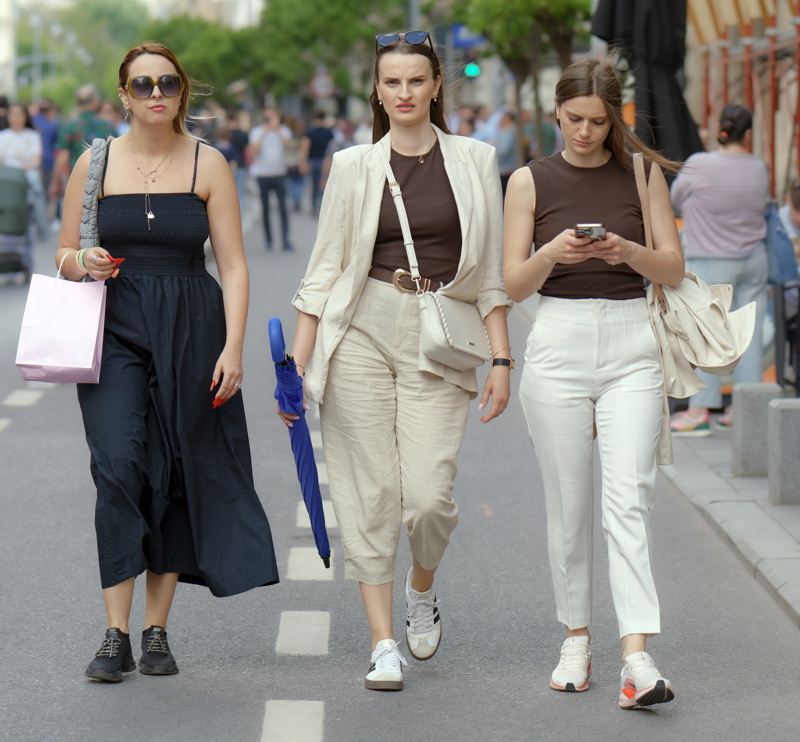 Three young women walking together on a pedestrian street